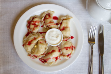 Dumplings with topping and sour cream