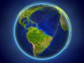 French Guiana from space on planet Earth with digital network representing international communication, technology and travel.