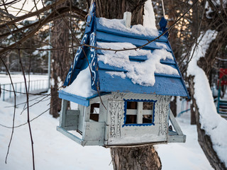 bird feeder in the form of a house under the snow, Novosibirsk, Russia