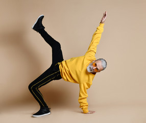 Happy senior millionaire man dancing in yellow sunglasses stylish fashionable men senior