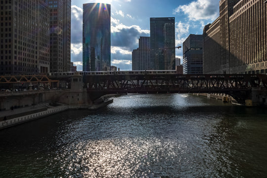 Sunbeams extend over an elevated train crossing the Chicago River