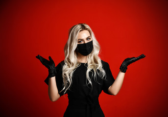 Beautiful woman in protective black medical mask with spread hands open palms for free text space