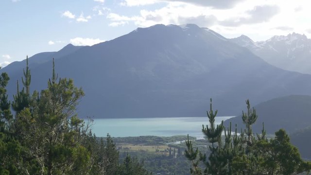 A mountain is behind some mist with a lake at the bottom.