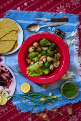 Baked, roasted, grilled vegetables mix assortment with Mexican tacos - corn flat breads. Vegan happy Christmas food lunch on red tablecloth. Vegetarian traditional holiday dinner