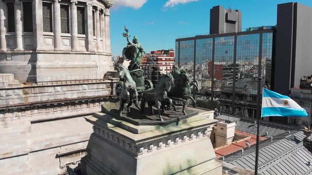 Aerial drone view of Buenos Aires national congress parliament building with dome roof, roman horse carriage statute and argentine flag