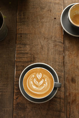 a cup of latte art coffee on wooden background