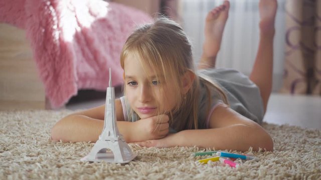 Little girl at children room dreaming about vacation. Child dreaming about travel to Paris. Vacation and travel concept.