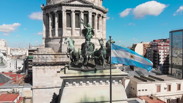 Aerial drone view of Buenos Aires national congress parliament building with dome roof, roman horse carriage statute and argentine flag