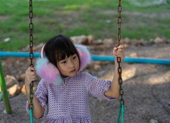 Asian Kids cute little girl Playing the playground swing