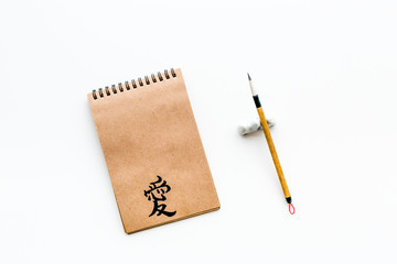 Chinese traditional calligraphy concept. Asian hieroglyph love in craft paper notebook near special...