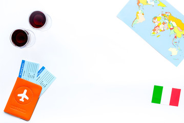 Gastronomical tourism. Italian food symbols. Passport and tickets near italian flag, glass of red wine, map of the world on white background top view copy space border