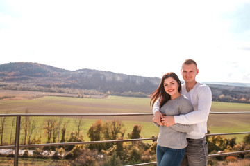 Romantic young couple hugging and smiling outdoors.