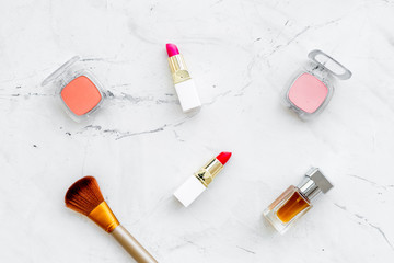 Set of pink cosmetics. Lipstick, bulk, eyeshadow, perfume near brushes on white background top view