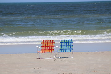 Beach chairs in the surf.
