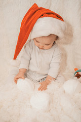 a naked newborn baby sleeps in a Christmas hat.