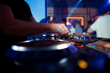 DJ entertaining a crowd in a party tent.