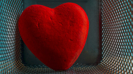 Red Wounded Velvet Heart in a Mesh Cage. Love, Home Violence, Loneliness, Freedom and Heartache Concept.
