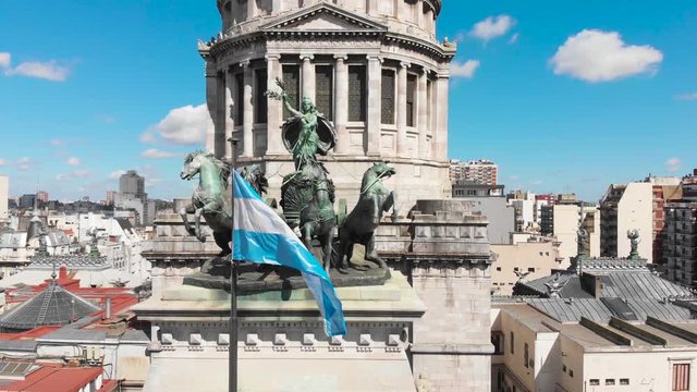 Aerial drone view of Buenos Aires national congress parliament building with dome roof, roman horse carriage statute and argentine flag