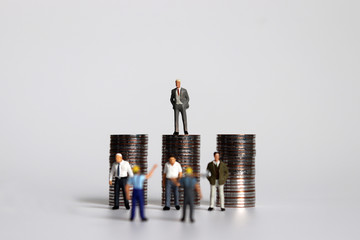 The concept of labor disputes between employers and workers. The pile of coins and miniature people.