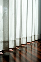 White transparent curtain and shadow of morning light and wooden floor