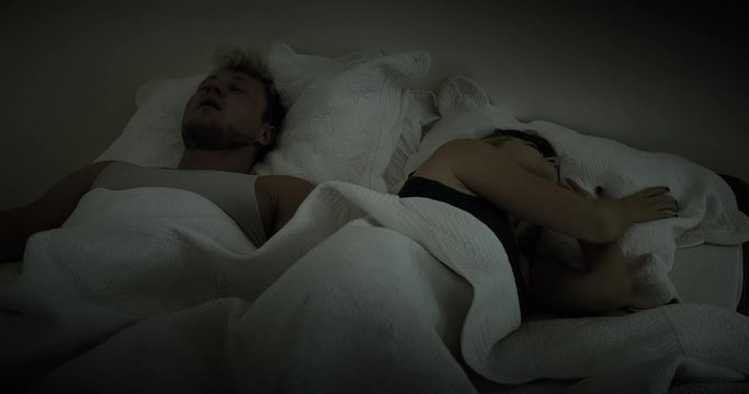 Woman buries her head under her pillow to get away from her partners loud snoring
