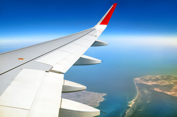 Obraz premium passenger airplane window seat wing view on black sea kerch strait scenery overlooking azov sea air travel aerial satellite panoramic transportation landscape background