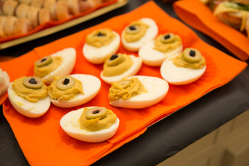 horizontal image with detail of boiled eggs decorated with olives and sauces