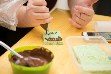 horizontal image with detail of the preparation of some desserts decorated with chocolate cream