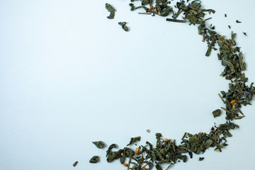 dry green tea leaves on a white background
