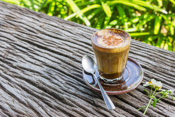 Latte Coffee and Daisy Flower and Spoon on Wood Table on Green Tree Background Right