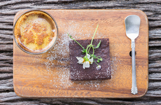 Chocolate Brownie Cake and Coffee and Daisy on Chopping Board on Wood Table Flatray