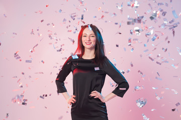 New Year, Saint Valentine's day and holidays concept - Cheerful young woman have fun while confetti falling on her.