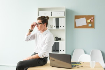 Business, humor and people concept - Young man in white shirt sitting on wooden table