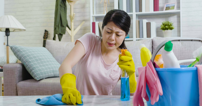 female houseworker frowning cleaning up