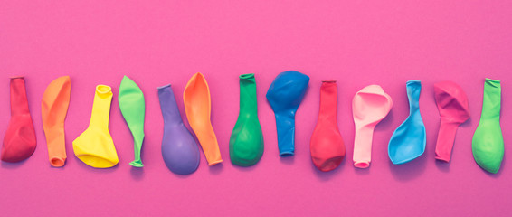 Banner Set of colored balloons on pink background Flat lay top view