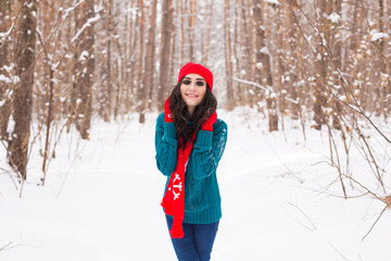 Fototapeta na wymiar Beautiful young woman walking in the winter snowy nature