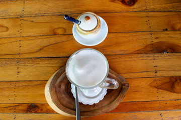 Cappuccino hot coffee on wooden table in coffeeshop and restaurant