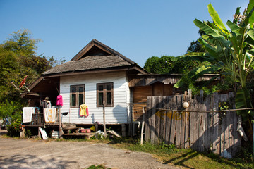 Thai women people washing clean clothes and hanging dry clothes in the sun at front of old house at Chiang Rai, Thailand