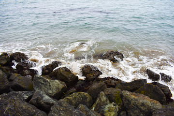 Splendorous waves of water crashing on rocks in the beach