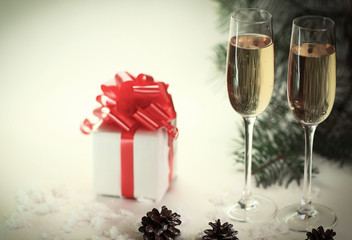 two glasses with champagne and cones on the Christmas background