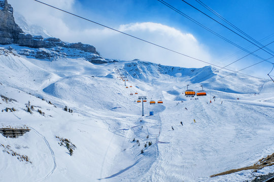 Winter landscape ski chair lift and skiers in Switzerland