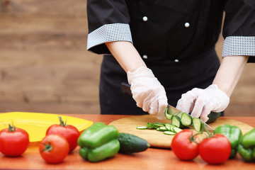 The cook cuts fresh farm vegetables
