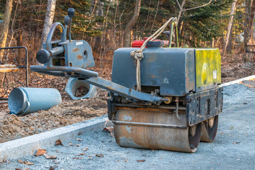 Manual compact asphalt roller for tamping soil at a construction site