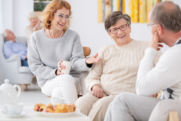 Group of elderly people talking and enjoying each other's company at Senior club