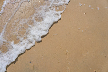 Soft wave of the sea on the sandy beach as background