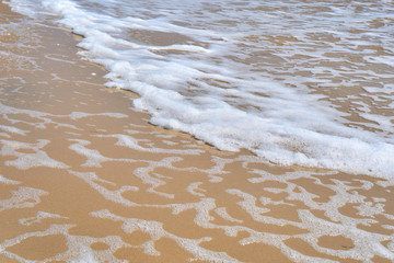 Soft wave of the sea on the sandy beach as background