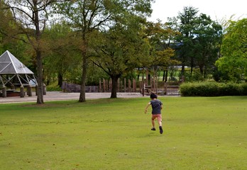 芝生の公園を走るキッズ