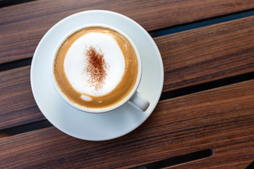 Hot coffee on wood background.