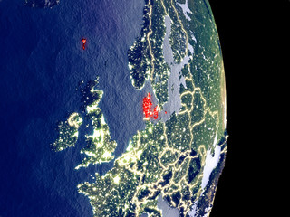 Satellite view of Denmark at night with visible bright city lights. Extremely fine detail of the plastic planet surface.