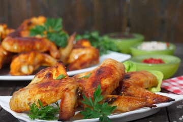 Roasted chicken wings with spices on wooden background